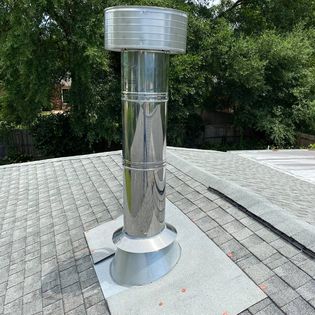 Standard prefab chimney cap installed on a factory-built chimney to help keep out rain, debris, and animals.