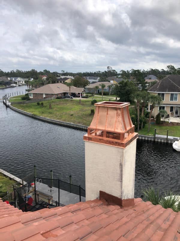 Custom copper chimney shroud professionally installed to enhance the chimney's appearance and provide protection.