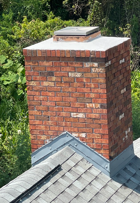 Freshly waterproofed brick chimney with protective masonry treatment applied to help prevent water intrusion.