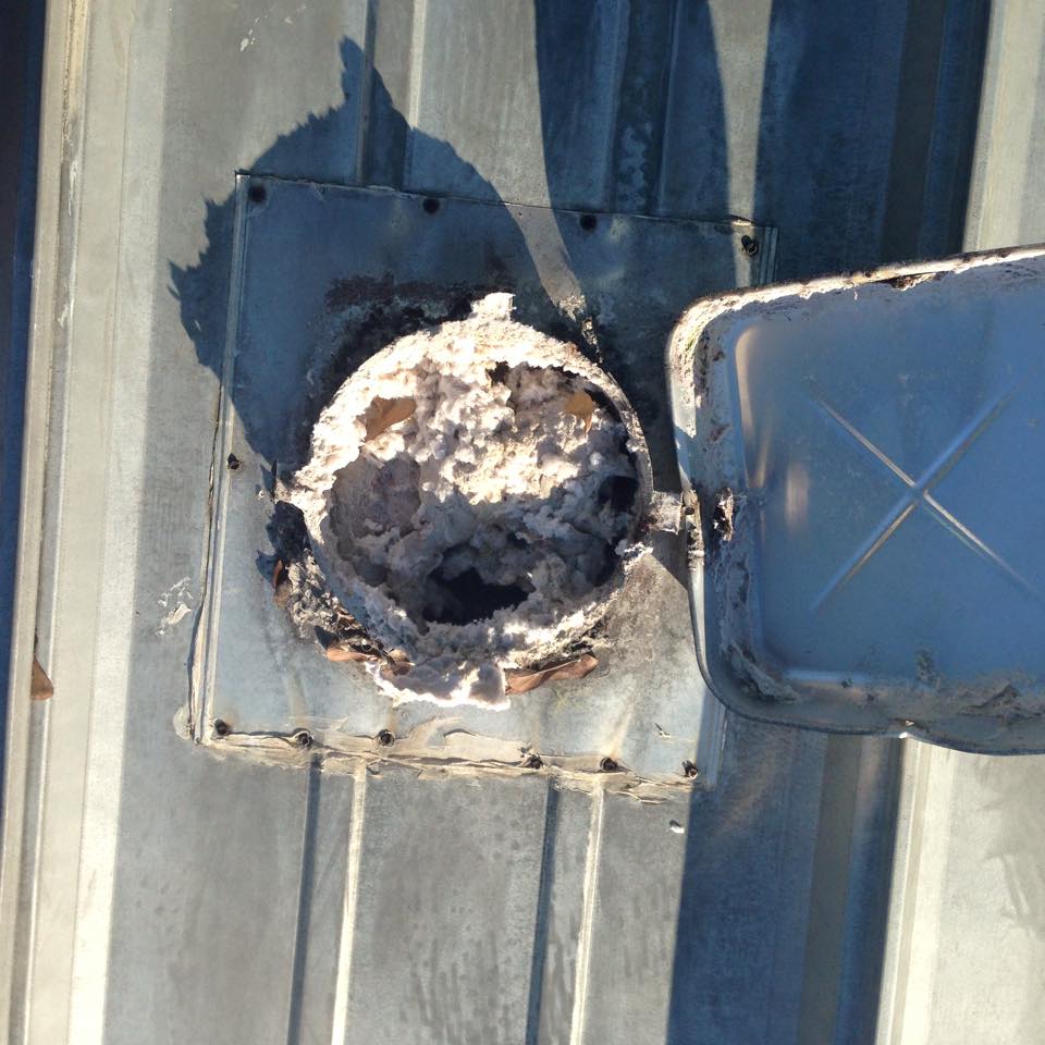 Clogged dryer vent filled with heavy lint buildup before professional dryer vent cleaning.