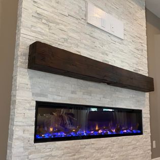 Custom-built electric fireplace with stone facade and tailored mantle adding style and function to the living space.