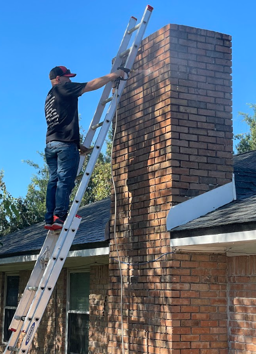 Pressure washing a chimney exterior to remove dirt and buildup before waterproofing application.