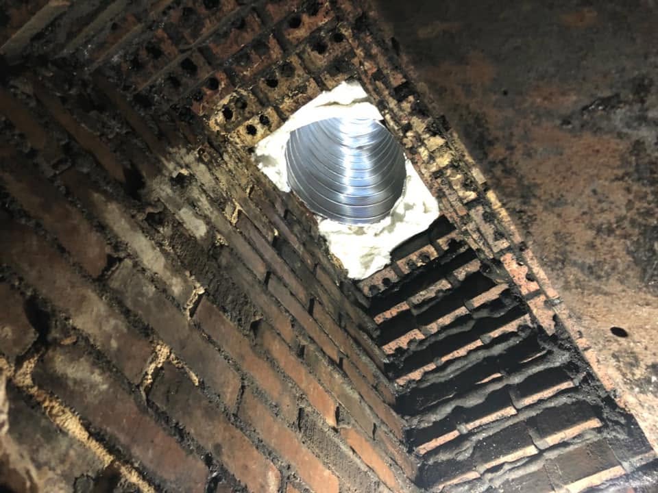 Exposed brick smoke chamber before restoration showing rough masonry surfaces requiring professional resurfacing.