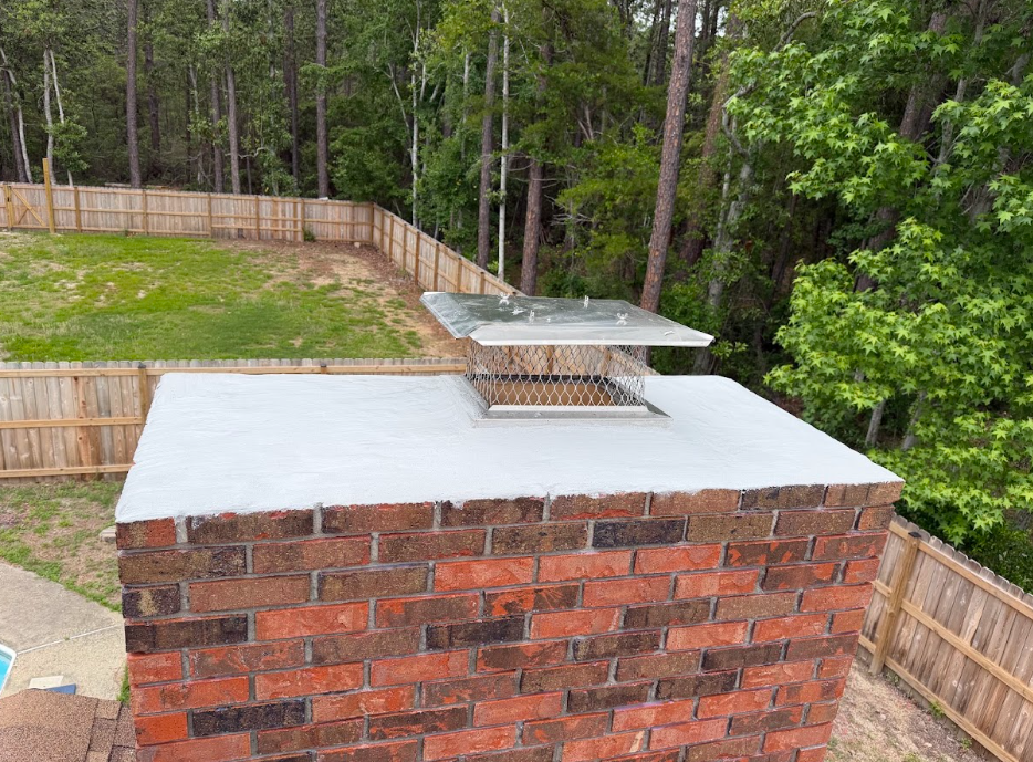 Standard masonry chimney cap installed on top of a brick chimney to help protect against water intrusion and weather damage.